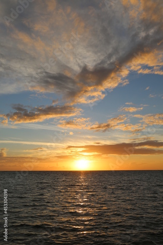 Beautiful yellow sunset over the ocean and different color sky