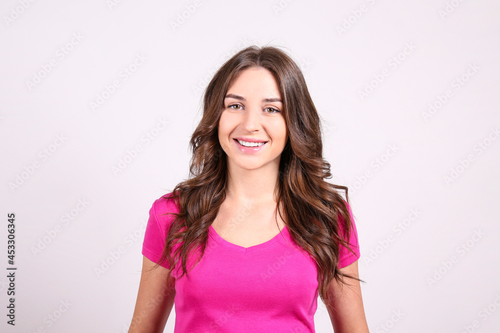 Young beautiful brunette woman with long wavy hair wearing pink shirt, posing over white isolated background. Portrait of female model showing emotions. Close up, copy space. Young beautiful brunette woman with long wavy hair wearing pink shirt, posing over white isolated background. Portrait of female model showing emotions. Close up, copy space.