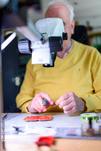 Arbeiten im Alter - Ein Senior arbeitet in seiner Elektronik-Werkstatt. photo