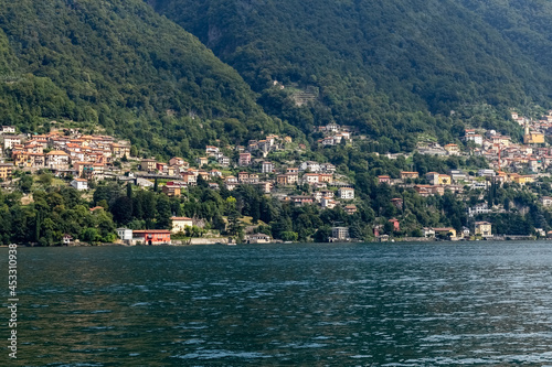 Como lake. Lake in the mountains. Lake in the mountains. City on the slope of the mountains. Beautiful summer seascape with blurred background. Card. Poster. Photo