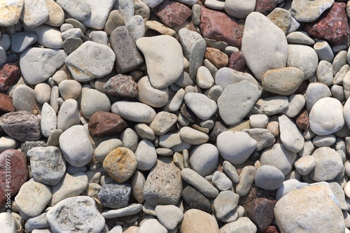 Sea pebbles background, small stones various shades, close up view, pebble texture.