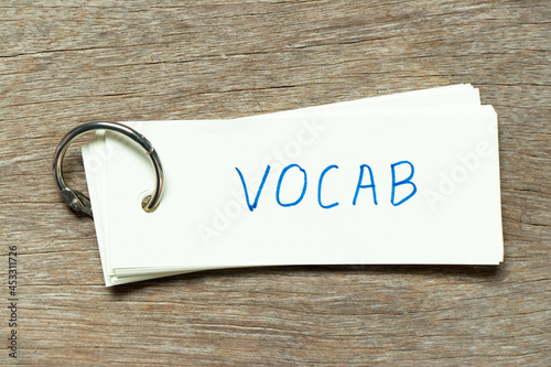 Flash card with handwriting word vocab on wood background photo