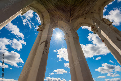 View of the sky with clouds from inside the ancient lookout tower made of white stone. Shining sun photo