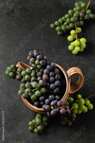 grape bunches in ceramic cups on a gray background, top view