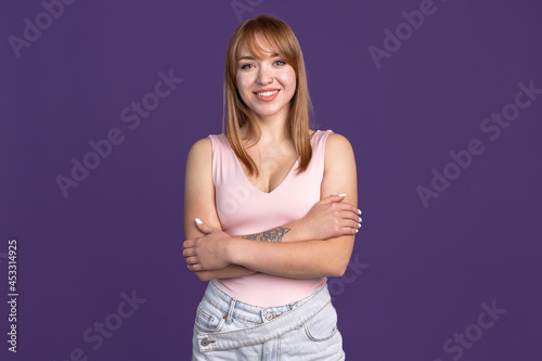 Half-length portrait of young beautiful girl isolated on purple studio background. Concept of human emotions, facial expression, youth, sales, ad.