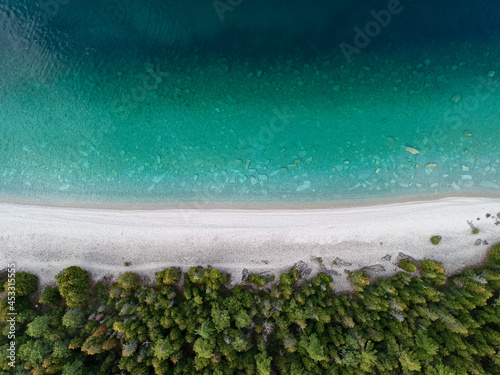 Aerial view of a crystal clear see through turquoise water, white sand beach and green pine trees forest, straight down perspective. Shot with drone. Space for copy. Georgian Bay, Bruce Peninsula. photo