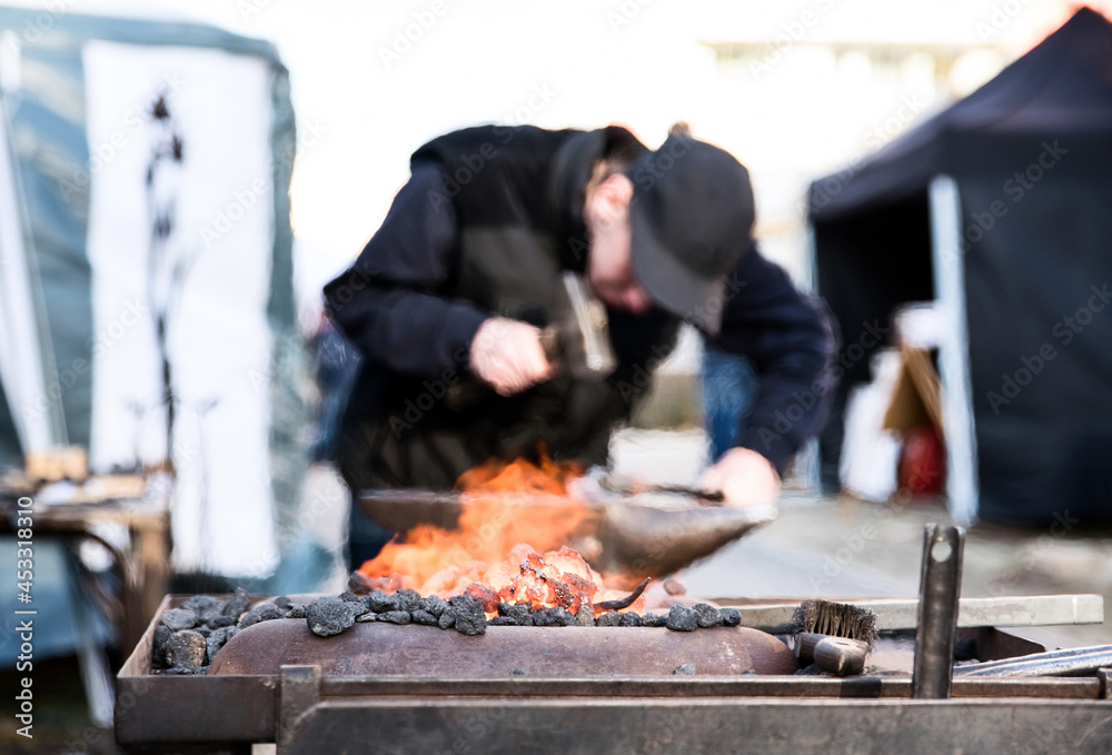 Close up of open fire and blacksmith working in the background. Ironwork concept. Close up of open fire and blacksmith working in the background. Ironwork concept.