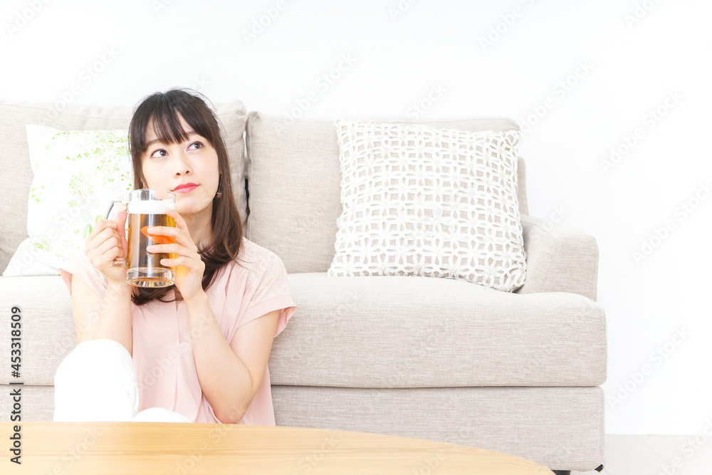 自宅でビールを飲む若い女性 自宅でビールを飲む若い女性