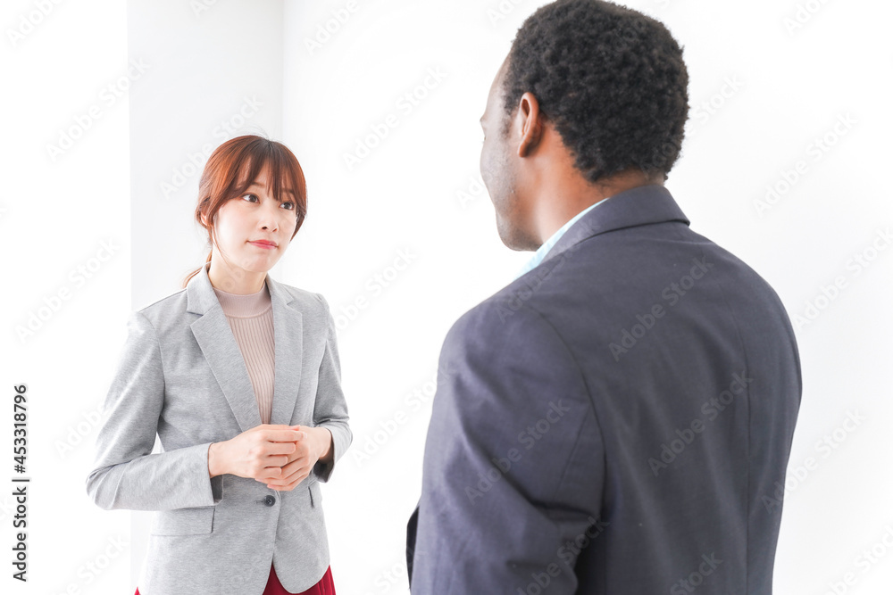 オフィスで意見交換をする2人のビジネスパーソン オフィスで意見交換をする2人のビジネスパーソン