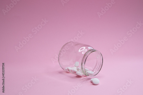 homeopathic globules and glass bottle close up on pink background. Alternative Homeopathy medicine herbs, healtcare and pills concept. Flatlay. copyspace for text. 