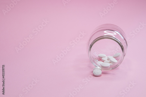 Photos homeopathic globules and glass bottle close up on pink background