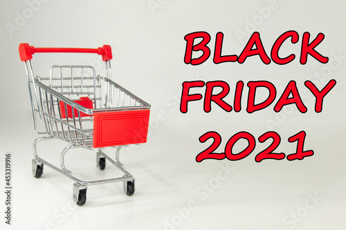 Black Friday 2021. Design for Black Friday accompanied by a metal shopping cart for the huge sales on these dates. White background. Space for text. Horizontal photography.