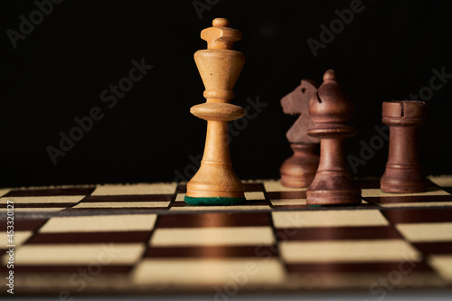 chess game with white king surrounded by black pieces, checkmate