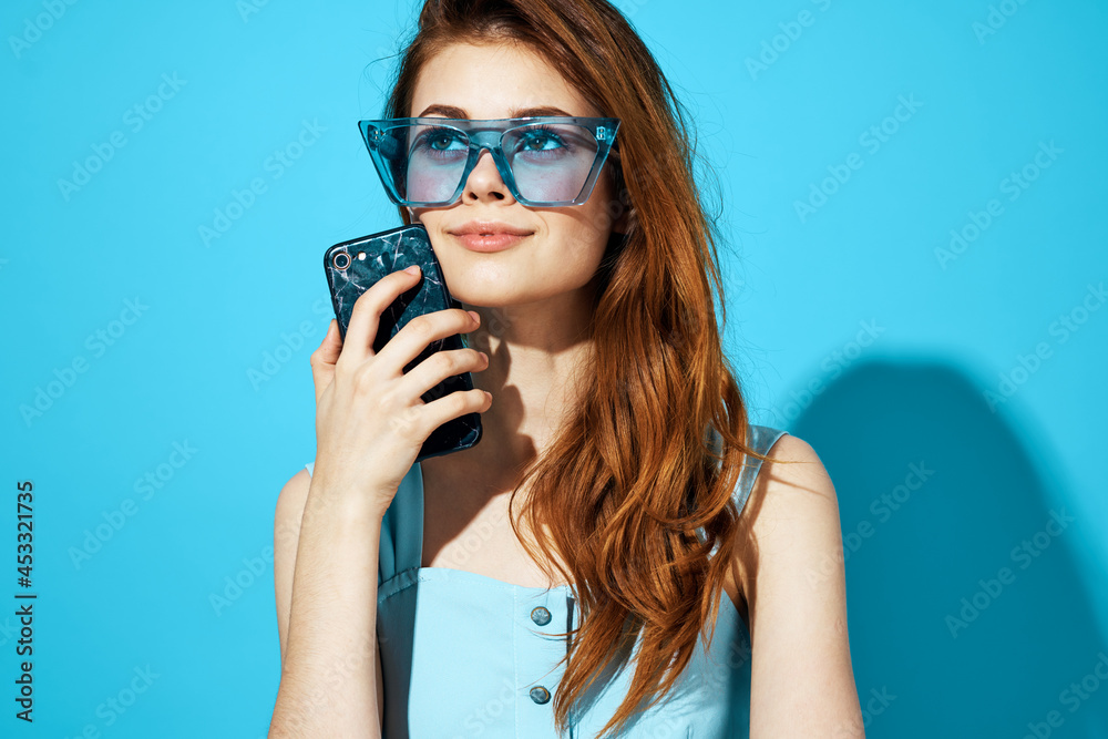 pretty woman in a dress and glasses with phone in hand isolated background pretty woman in a dress and glasses with phone in hand isolated background