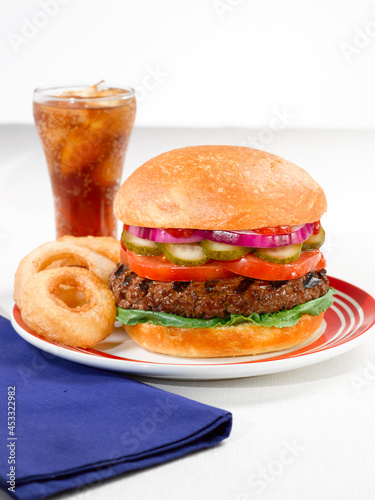 Burger with onion rings and a soda