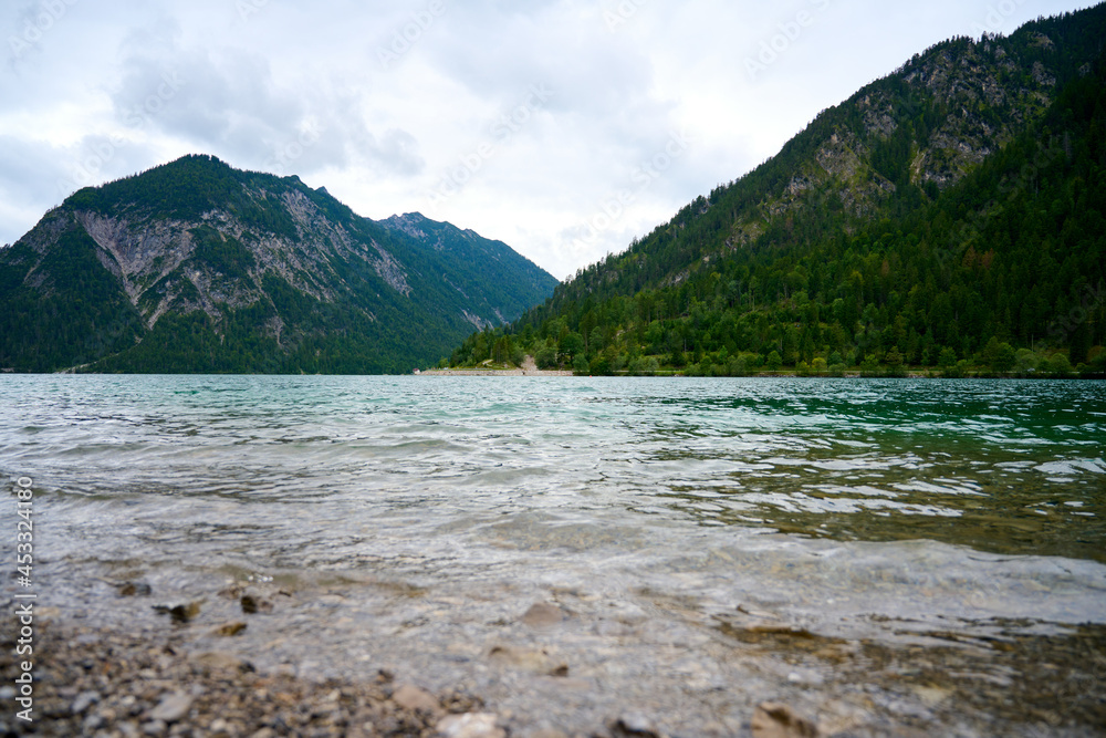 Picture over the waves of the Austrian lake Plansee. The lake is located in the middle of the alps between mountains. 