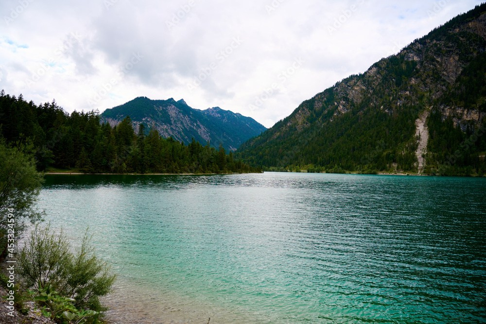 Picture over the waves of the Austrian lake Plansee. The lake is located in the middle of the alps between mountains. 