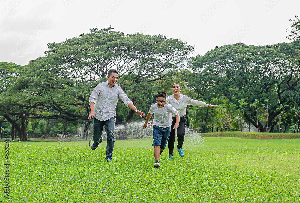 Parents and children happily run and play in park