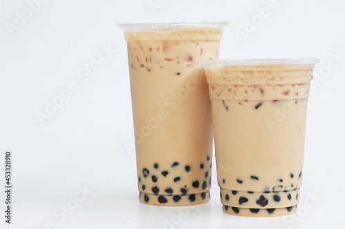 Two plastic glass Taiwan ice milk tea with boba bubble, Sweet drink big and small plastic cup on white background, Drink and food concept
