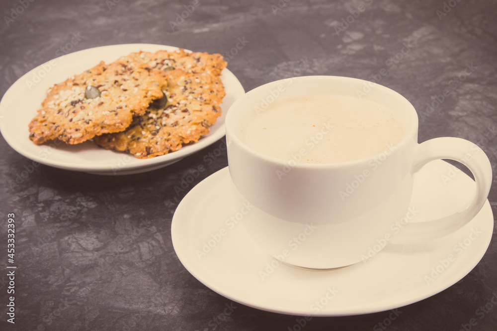 Cup of coffee with milk and fresh baked healthy oatmeal cookies. Delicious crunchy dessert. Vintage photo Cup of coffee with milk and fresh baked healthy oatmeal cookies. Delicious crunchy dessert. Vintage photo