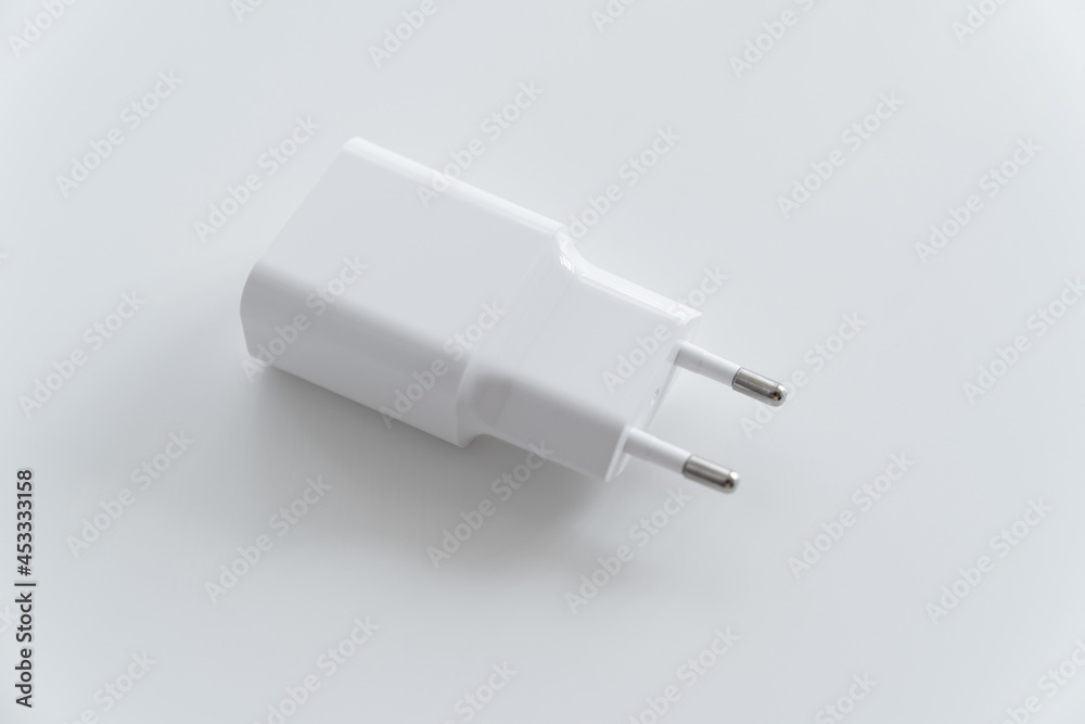 AC charger with USB connector for smartphone or tablet on a white background. AC charger with USB connector for smartphone or tablet on a white background.