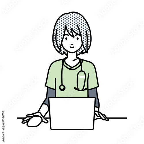 デスクで座ってPCを使っている看護師の女性