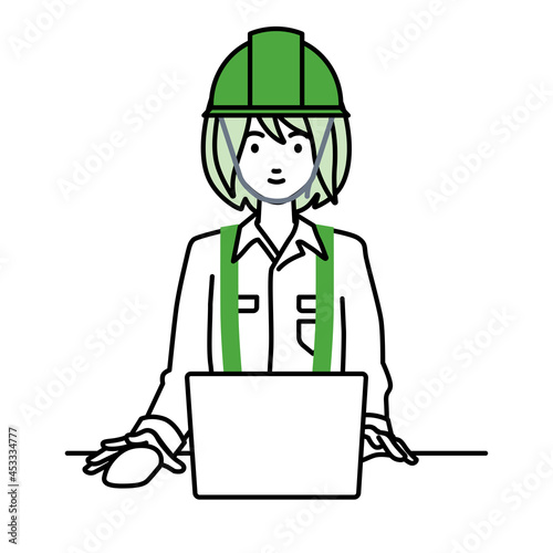 デスクで座ってPCを使っている工事現場の女性