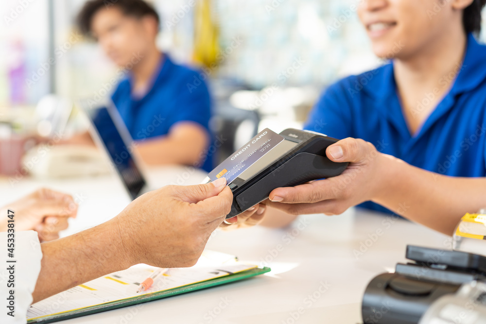 Hand of customer using credit card for payment at the auto car repair shop. Pay by credit card. Pay online with credit card Hand of customer using credit card for payment at the auto car repair shop. Pay by credit card. Pay online with credit card