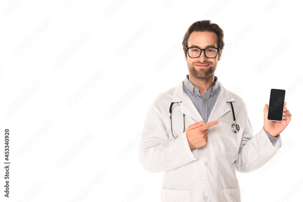 Smiling doctor pointing at smartphone isolated on white Smiling doctor pointing at smartphone isolated on white