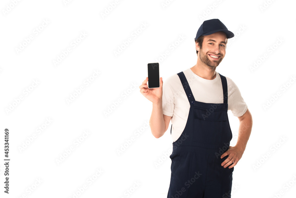 Smiling cleaner holding smartphone and hand on hip isolated on white Smiling cleaner holding smartphone and hand on hip isolated on white