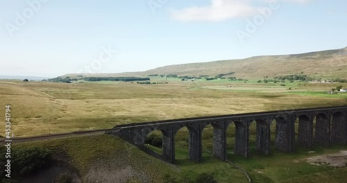 Aerial Pan along the Ribblehead Viaduct. The Viaduct is in West Yorkshire. It was opened in 1875 after a five year build across Batty Moss in the Ribble Valley photo