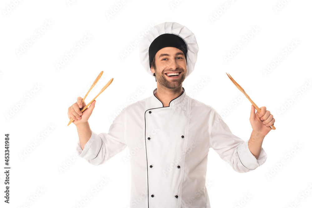 Smiling chef holding wooden tweezers isolated on white Smiling chef holding wooden tweezers isolated on white