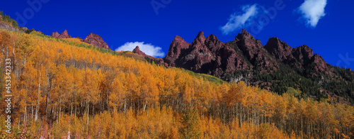 Panoramic view of Rocky mountains surrounded with bright fall foliage