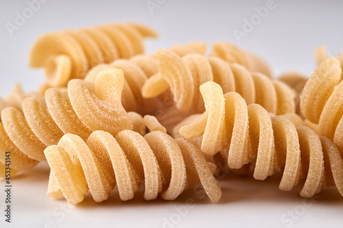 spiral noodles close up on white background, pasta and macaroni