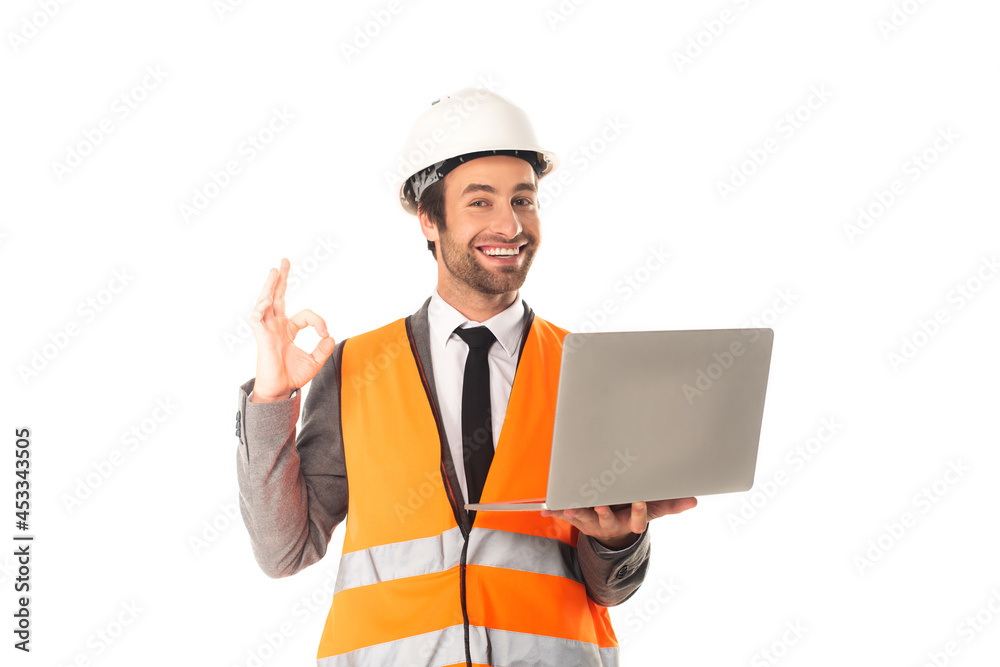 Engineer with laptop showing ok gesture isolated on white Engineer with laptop showing ok gesture isolated on white