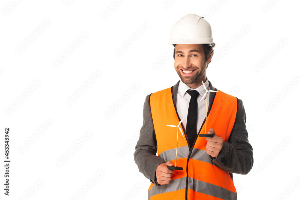 Smiling engineer holding models of wind turbines isolated on white Smiling engineer holding models of wind turbines isolated on white