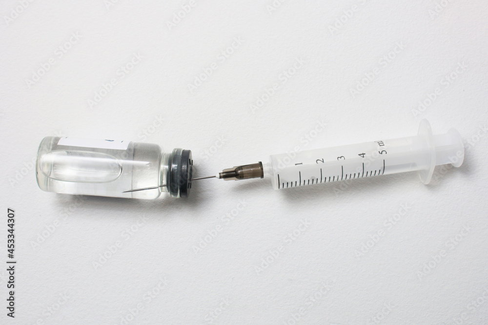 Vaccine vial and syringe on white on light grey background. Stock Photo ...