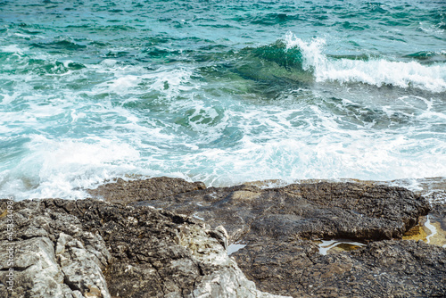 view of water with waves with rocky cliff