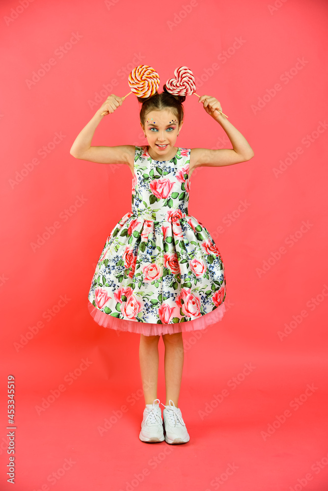 Happy smiling girl with sweets on a pink background, a holiday Happy smiling girl with sweets on a pink background, a holiday