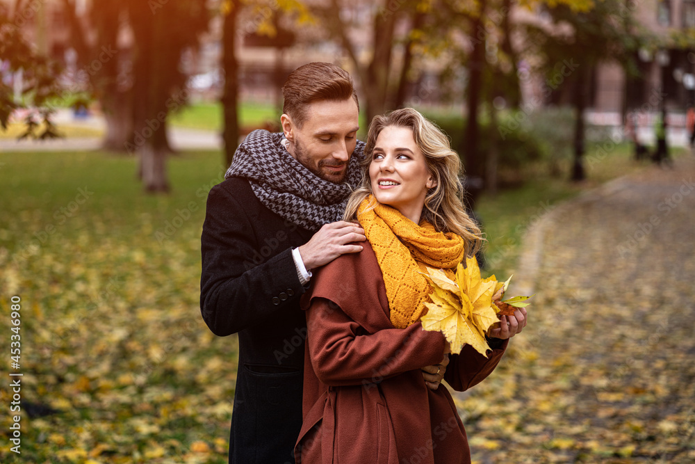 Loving couple in an autumn park. Husband and a wife smile looking at each other in the autumn park. Outdoor shot of a young couple in love having great time in a autumn park. Loving couple in an autumn park. Husband and a wife smile looking at each other in the autumn park. Outdoor shot of a young couple in love having great time in a autumn park.