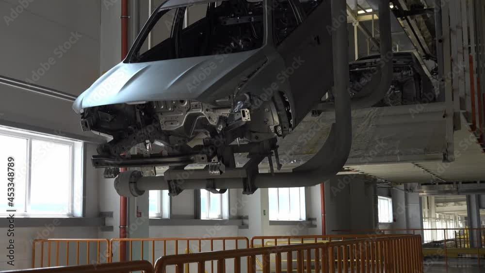 Car bodies on the production line. Skeleton of car moves along the conveyor. Car factory. Modern technologies at the plant. Industry concept. Car bodies on the production line. Skeleton of car moves along the conveyor. Car factory. Modern technologies at the plant. Industry concept.