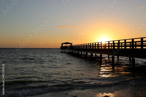 Pier in the sunrise on the sea beach