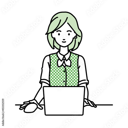デスクで座ってPCを使っている事務員制服の女性