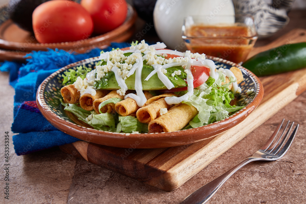 Flautas de pollo con lechuga, tomate, crema y queso Stock Photo Adobe