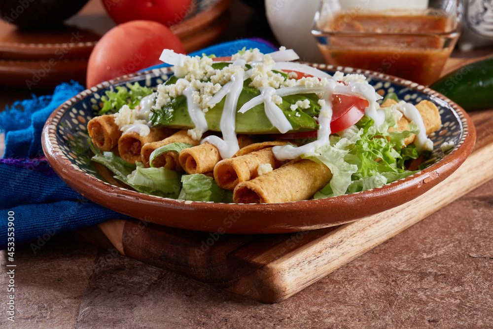 Flautas de pollo con lechuga, tomate, crema y queso Stock Photo Adobe