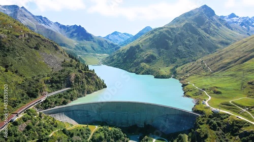 Water dam and reservoir lake in Swiss Alps generating hydroelectricity. Aerial view of arch dam between mountains. Hydropower green energy for sustainable development against global warming. Zero CO2