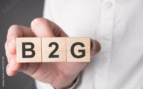 Business man hand holding wooden cube with b2g text. Financial, marketing and business concepts photo