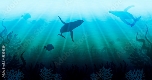 Underwater illustration with silhouettes of swimming whales and fish, seascape with endless emerald ocean and the sun's rays, deep water with waves, algae and corals on the bottom.