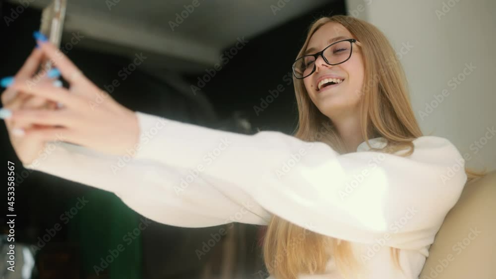 Young smiling hipster blond woman posing, takes selfies and streams video to social media from her smartphone. High quality 4k footage Young smiling hipster blond woman posing, takes selfies and streams video to social media from her smartphone. High quality 4k footage