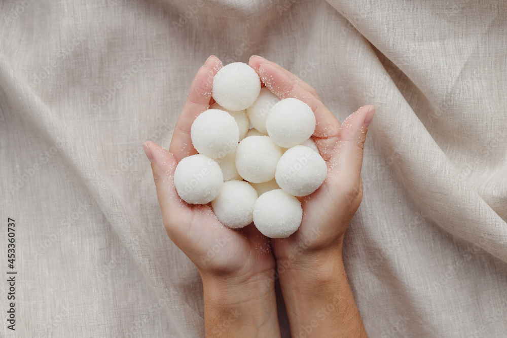 Female hands holding solid handmade natural shampoo or sugar scrub balls Female hands holding solid handmade natural shampoo or sugar scrub balls